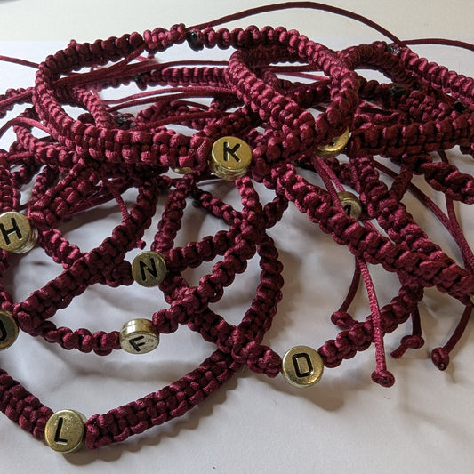Maroon braided bracelets with gold letter beads