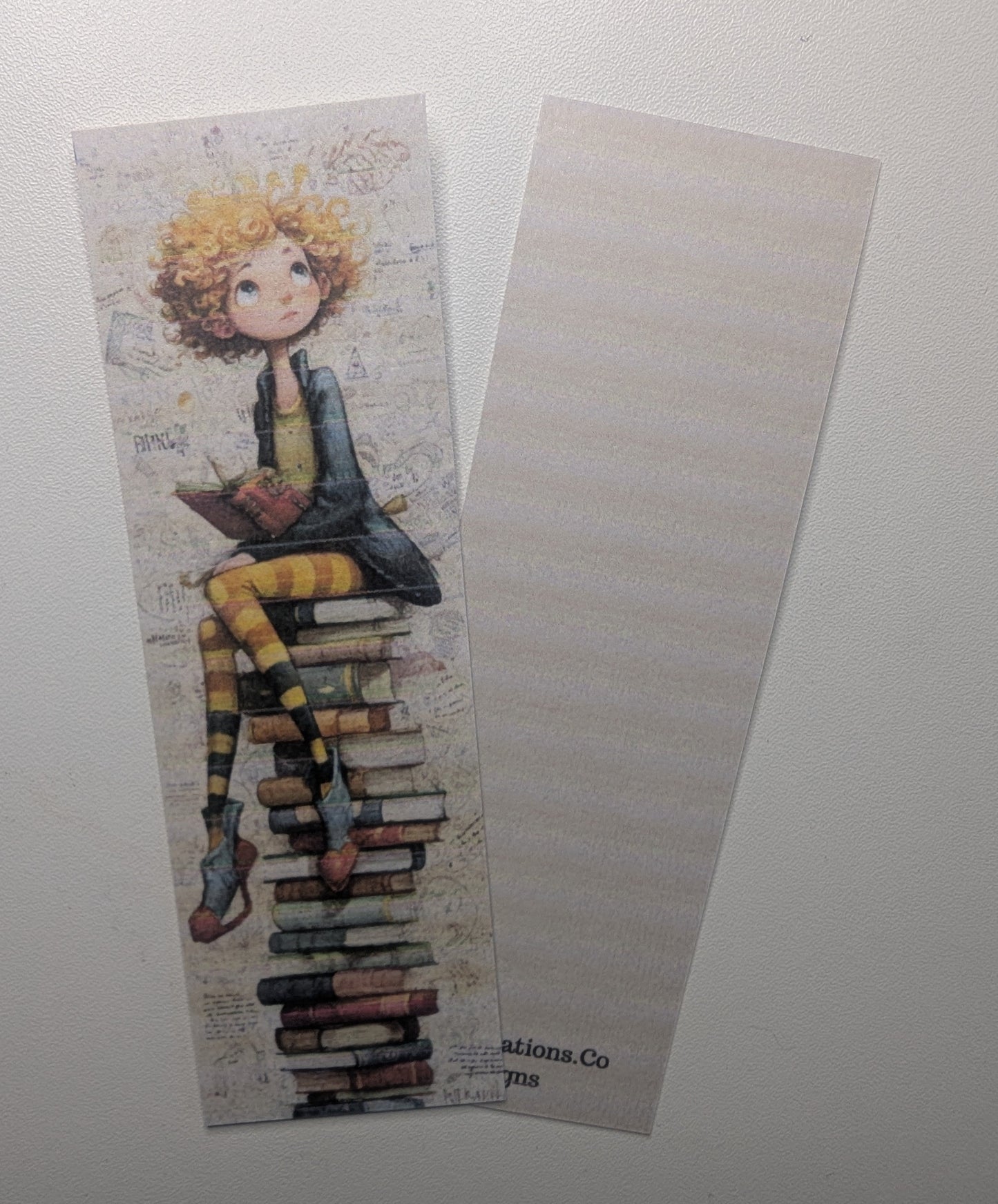 Bookmark with a design of a person sitting on books on a plain background