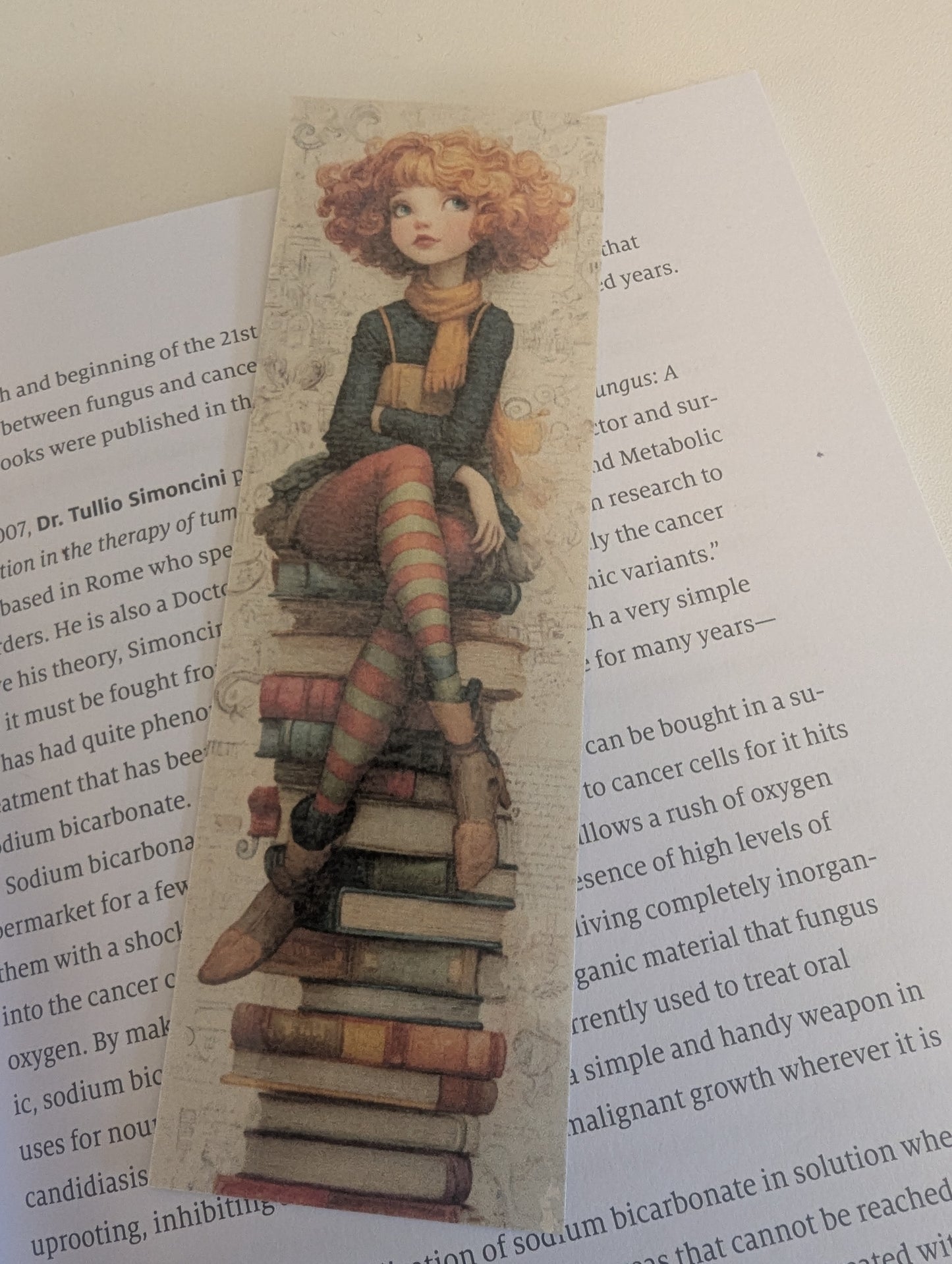 Bookmark with illustration of a person sitting on books on a page