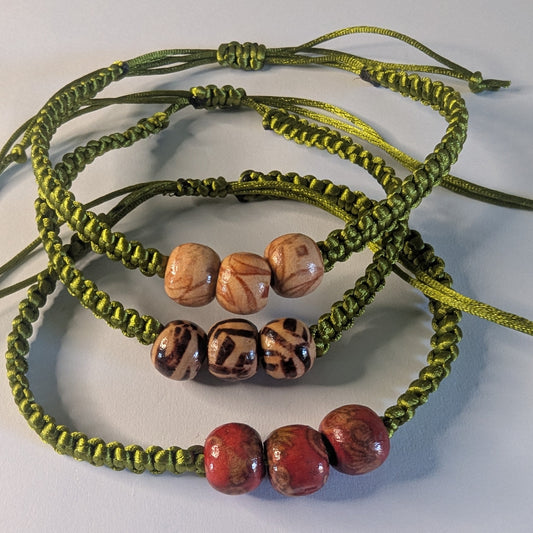 Green braided bracelets with various coloured beads.