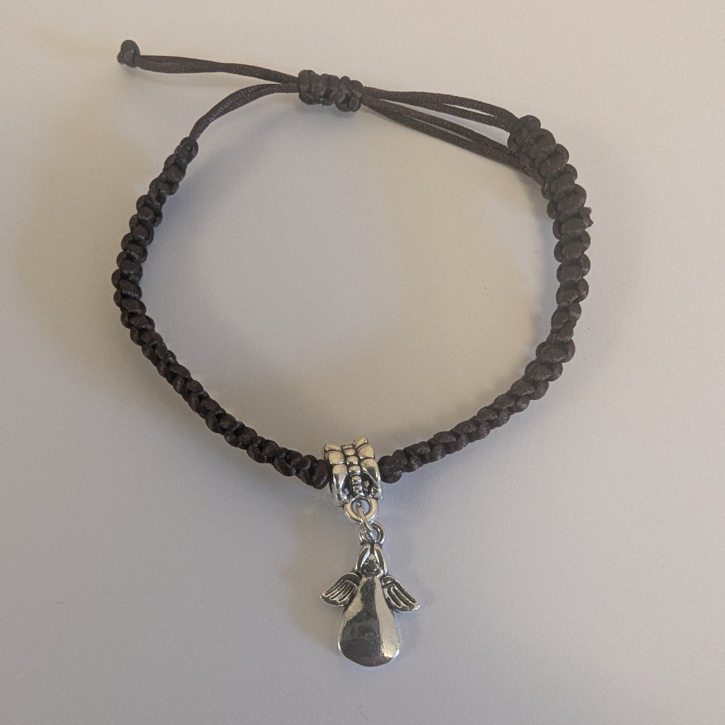 Bracelet with a dark cord and silver charm