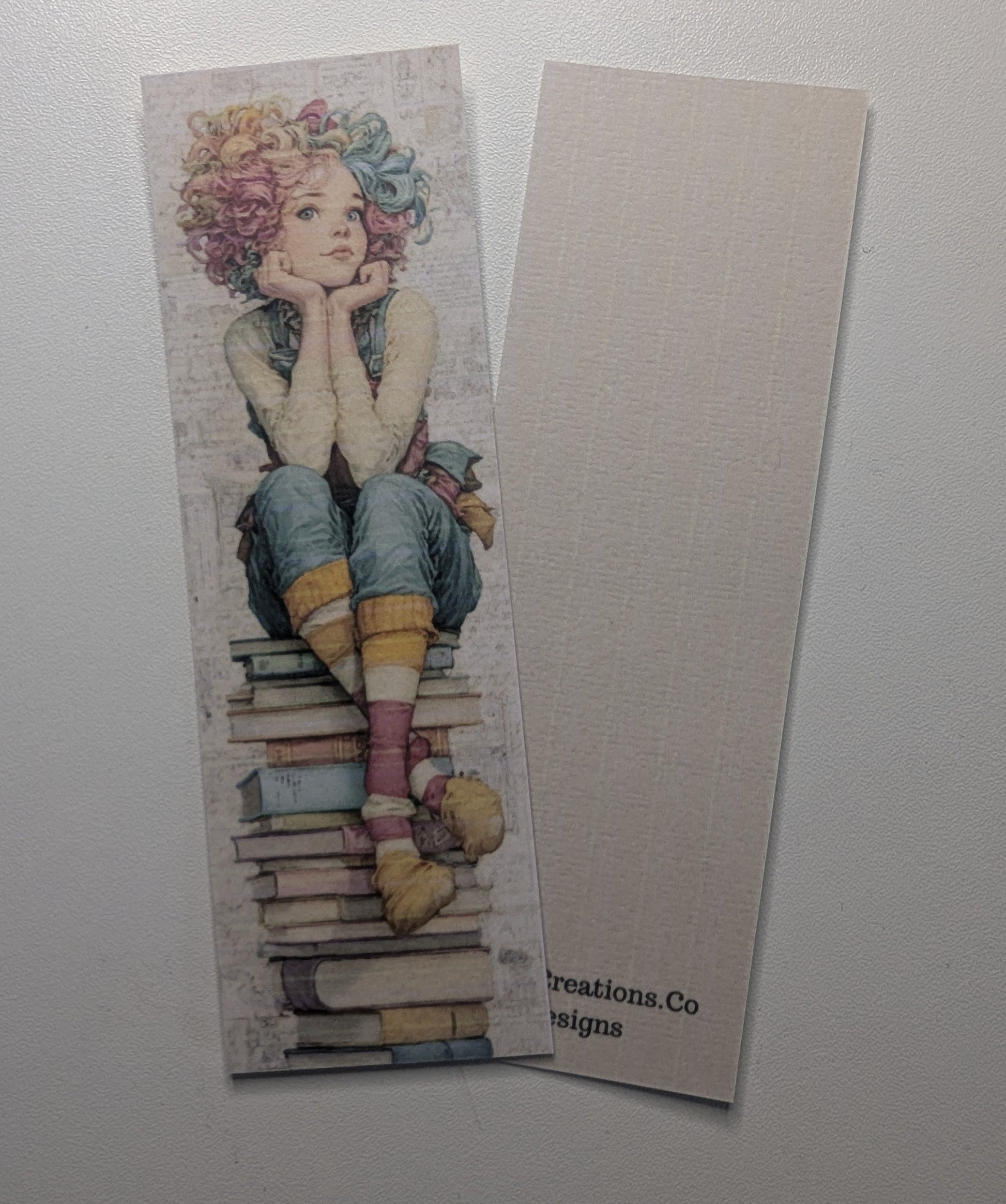 Bookmark with an illustration of a person sitting on books on a plain background